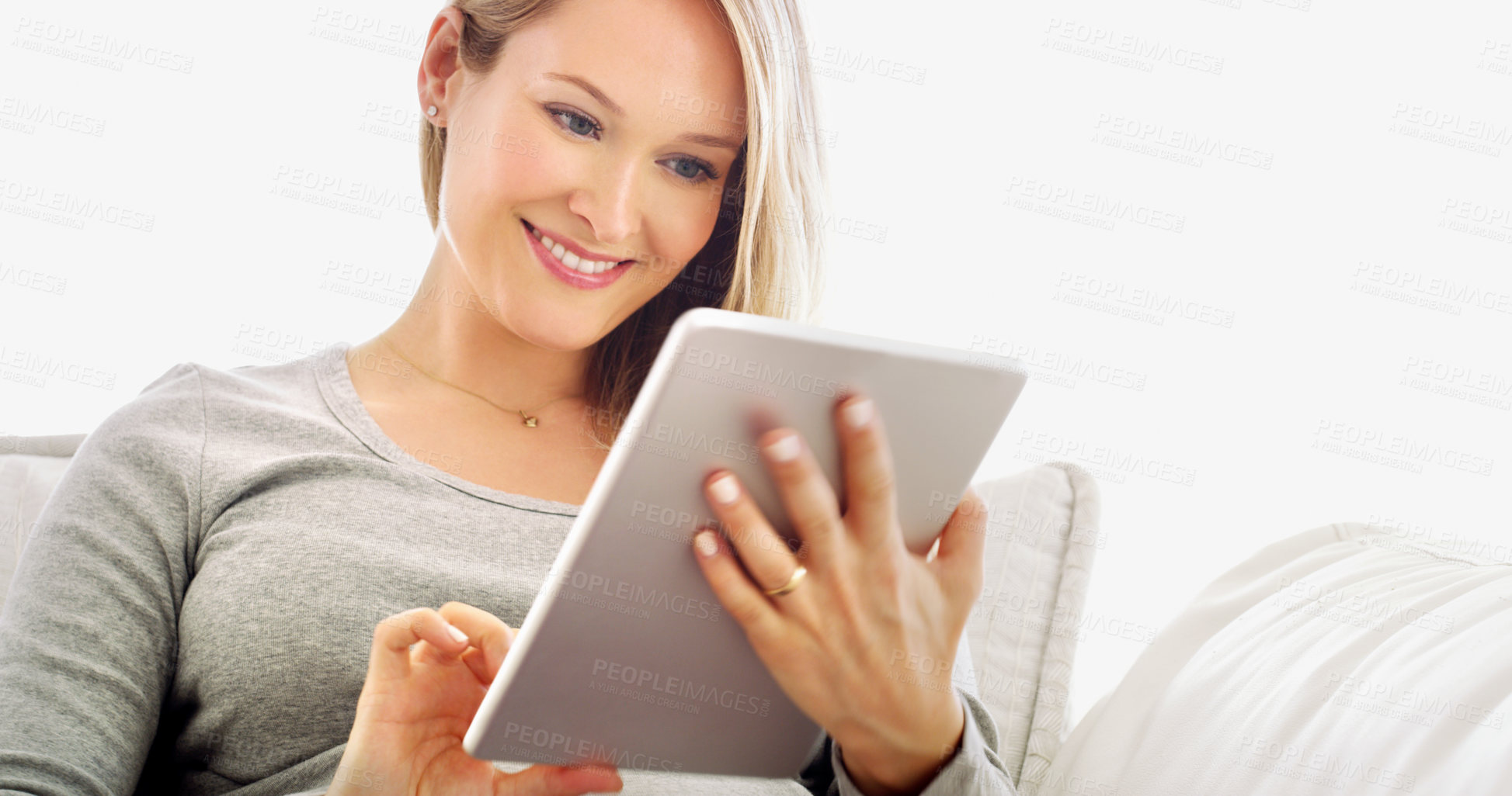 Buy stock photo Cropped portrait of an attractive young woman using a tablet in her home