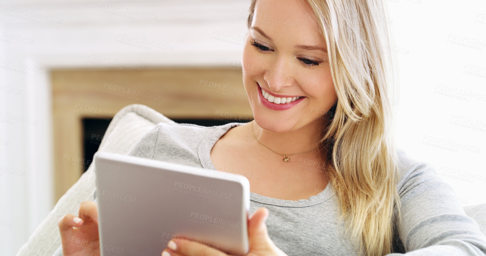 Buy stock photo Cropped portrait of an attractive young woman using a tablet at home