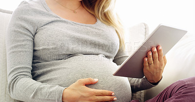 Buy stock photo Shot of an unrecognizable pregnant woman using a tablet at home