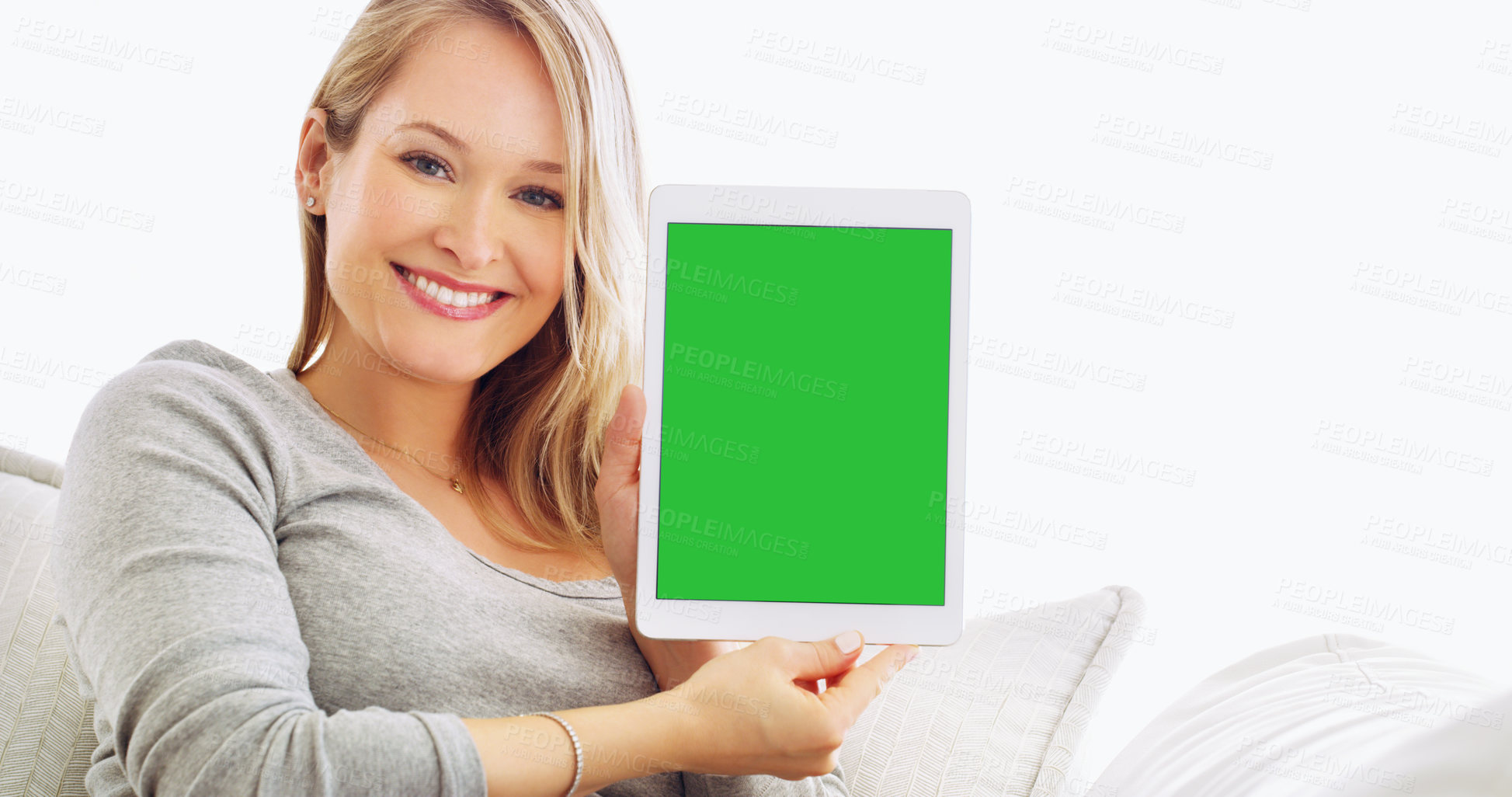 Buy stock photo Cropped portrait of an attractive young woman holding up a tablet at home