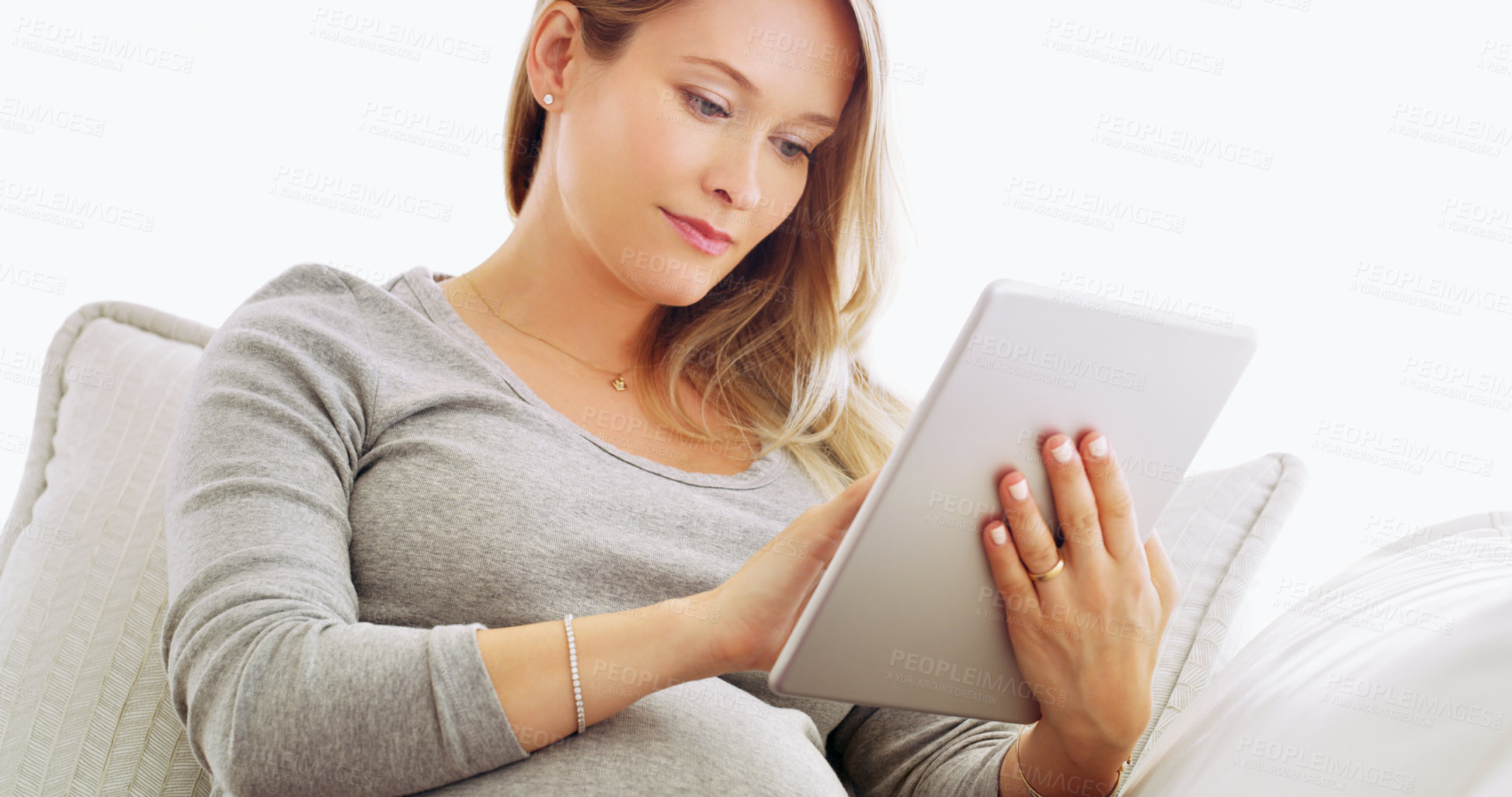 Buy stock photo Woman, pregnant and relax on sofa with tablet, telehealth app or ecommerce for baby care. Expectant mom, tech or research in home living room for maternity wellness, symptom relief or online shopping