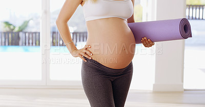 Buy stock photo Cropped shot of an unrecognizable young pregnant woman carrying a yoga mat