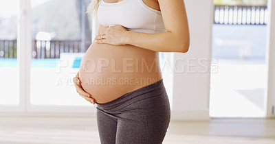 Buy stock photo Cropped shot of an unrecognizable young pregnant woman rubbing her baby bump