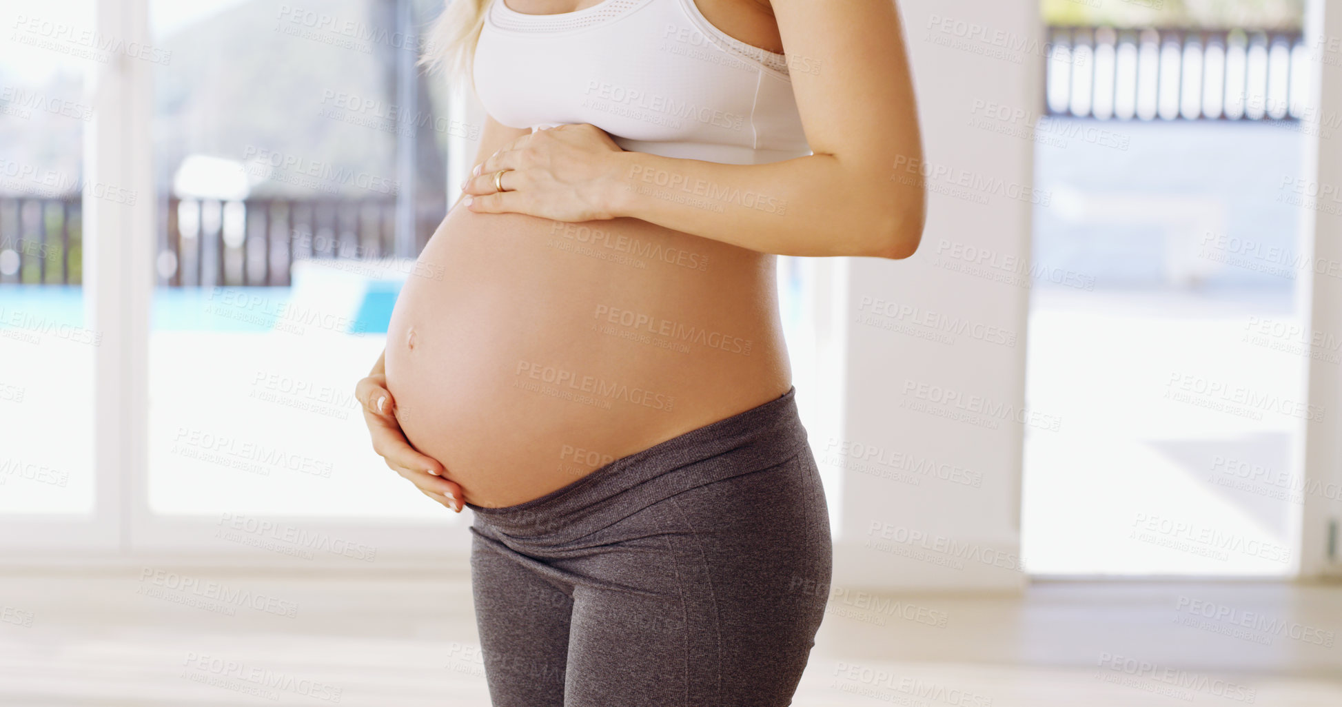Buy stock photo Cropped shot of an unrecognizable young pregnant woman rubbing her baby bump