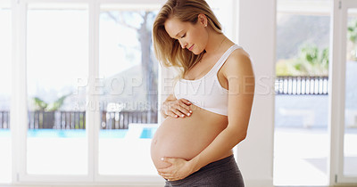 Buy stock photo Cropped shot of an attractive young pregnant woman rubbing her baby bump