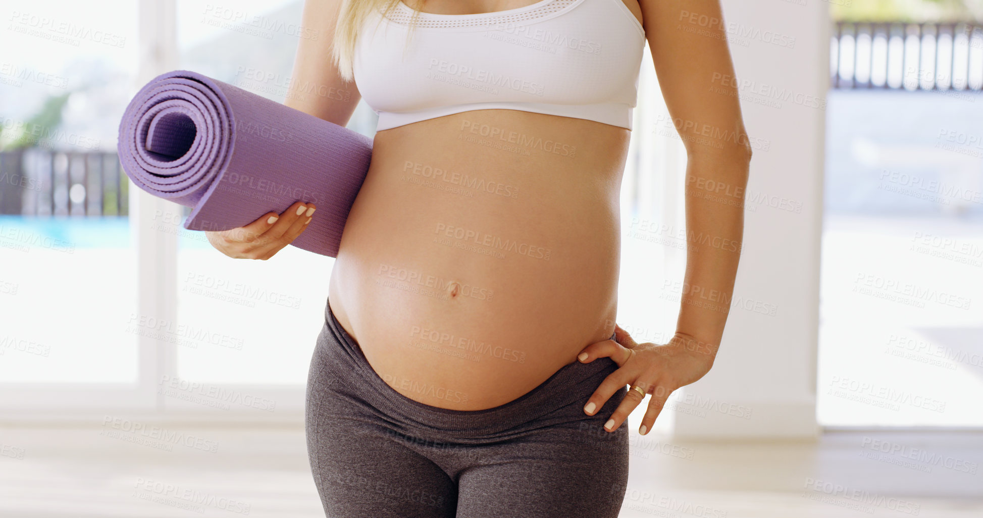 Buy stock photo Cropped shot of an unrecognizable young pregnant woman carrying a yoga mat