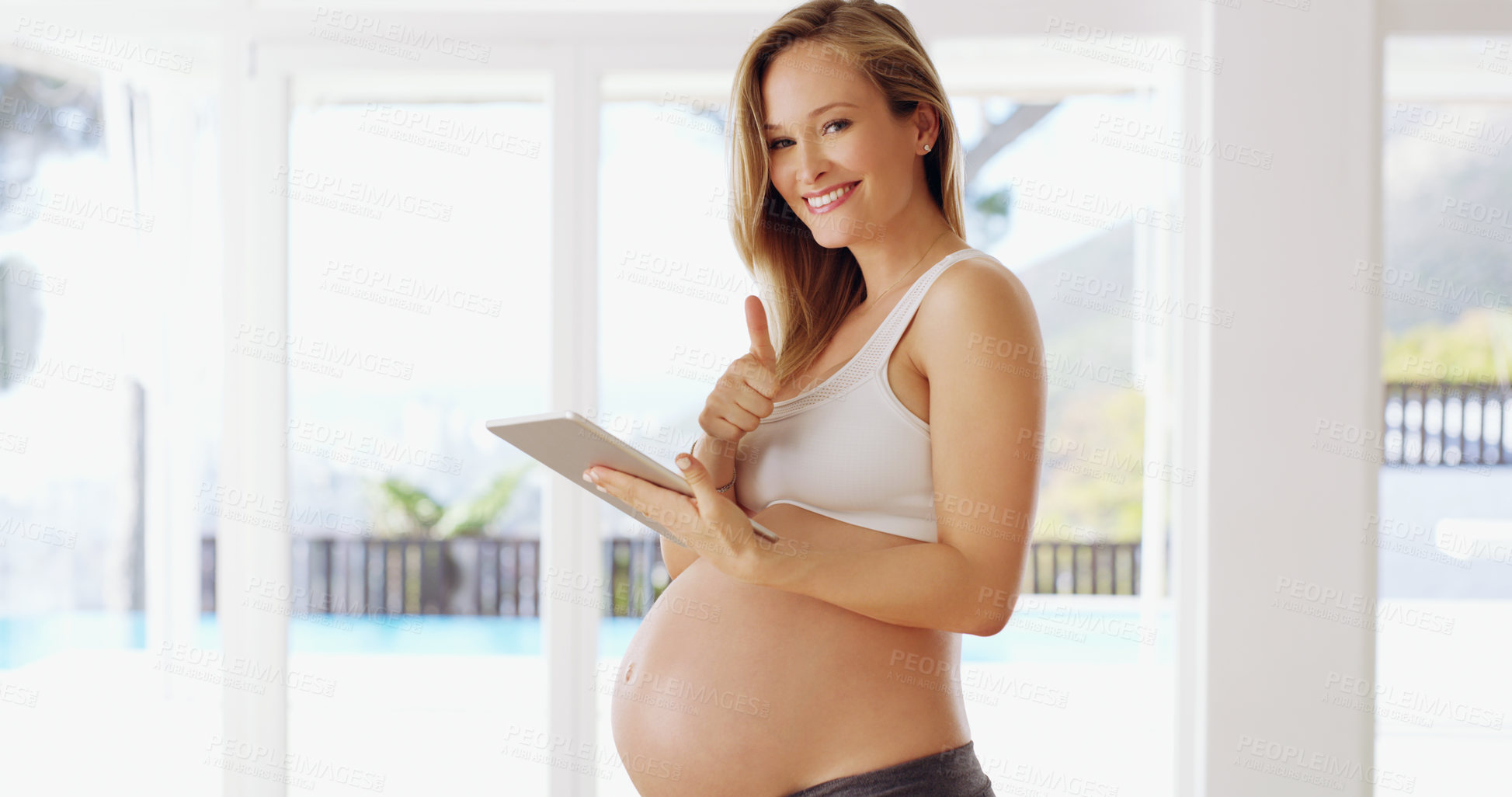 Buy stock photo Shot of a pregnant woman using a tablet at home