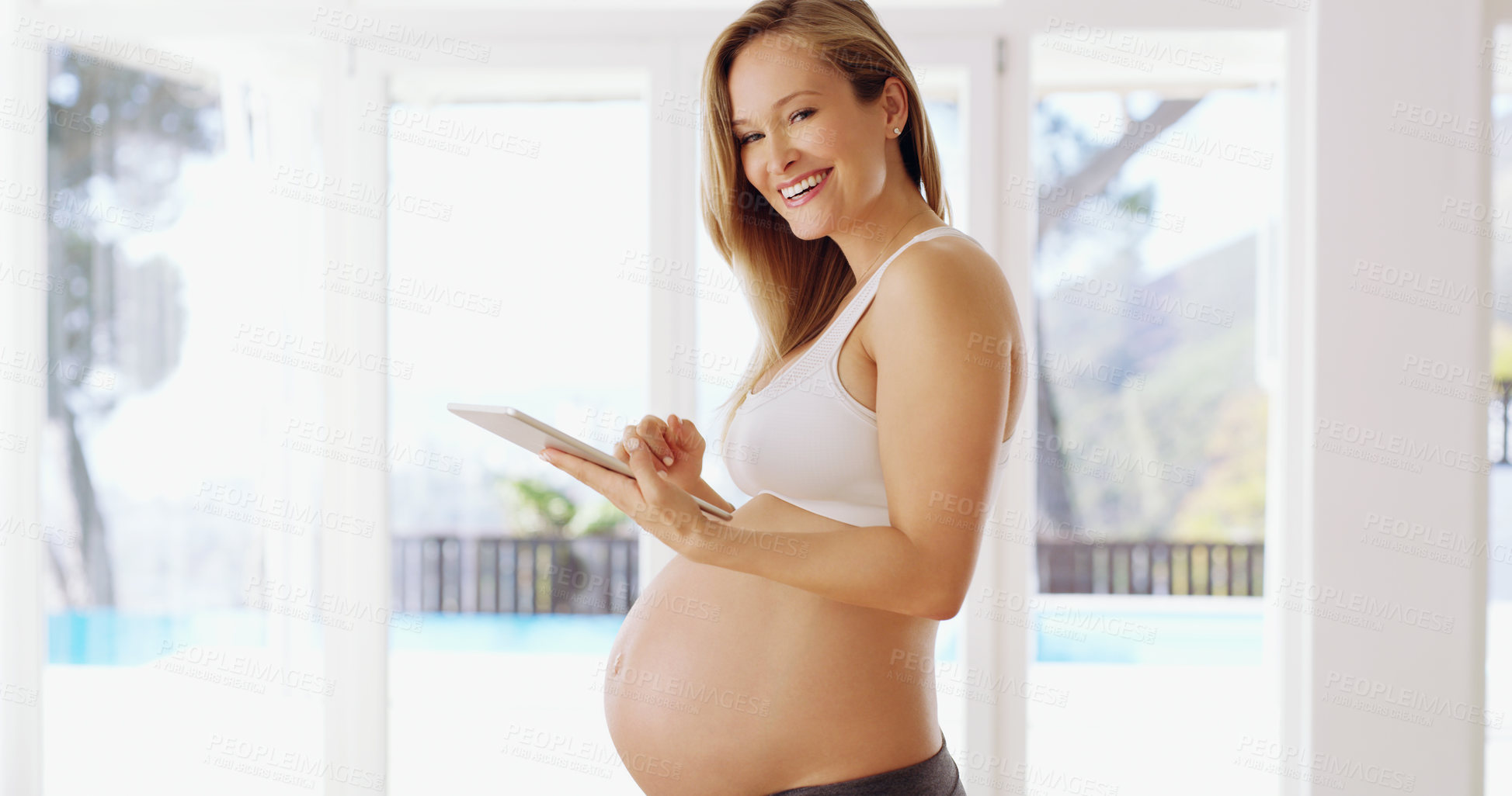 Buy stock photo Shot of a pregnant woman using a tablet at home