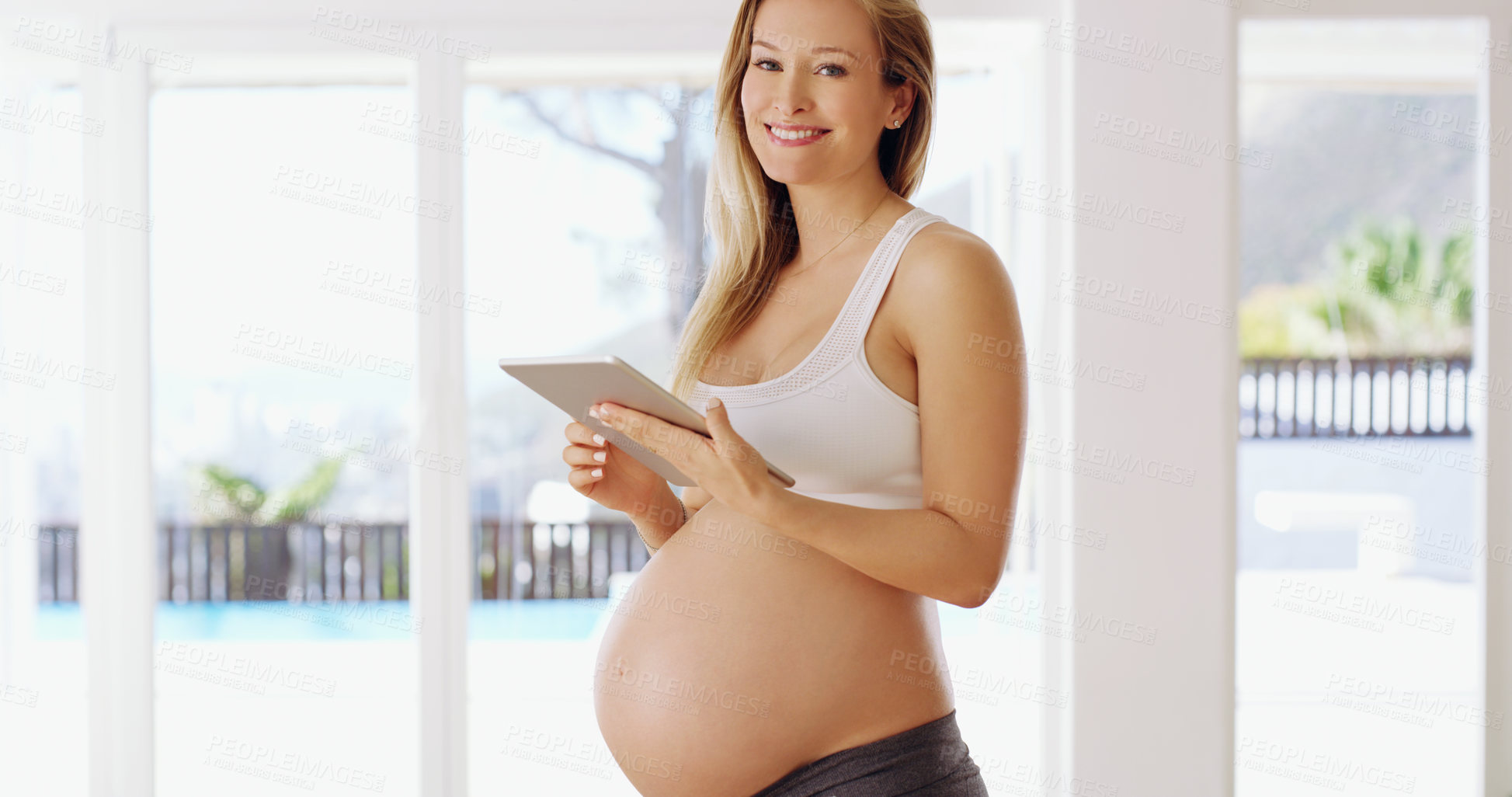 Buy stock photo Shot of a pregnant woman using a tablet at home