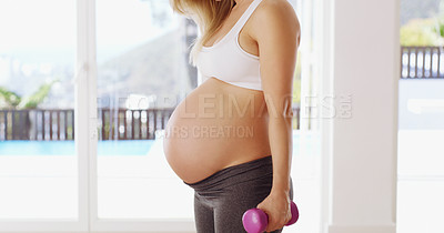 Buy stock photo Cropped shot of an unrecognizable young pregnant woman working out with dumbbells