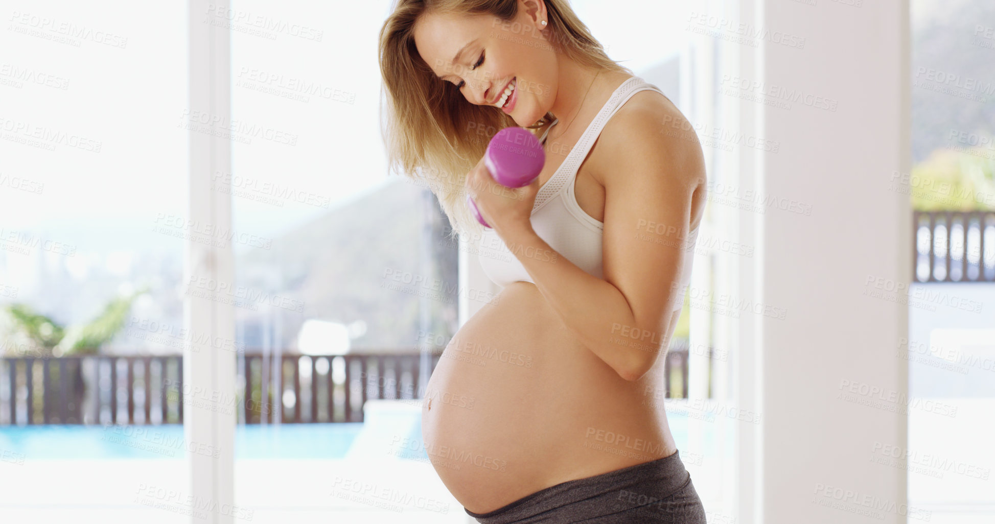 Buy stock photo Cropped shot of an attractive young pregnant woman working out with dumbbells