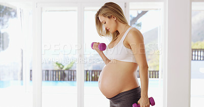 Buy stock photo Cropped shot of an attractive young pregnant woman working out with dumbbells