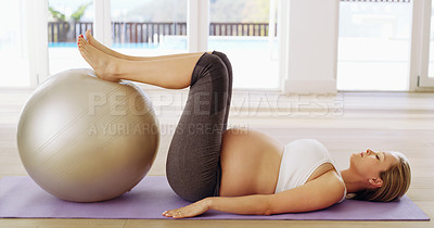 Buy stock photo Full length shot of an attractive young pregnant woman working out with an exercise ball