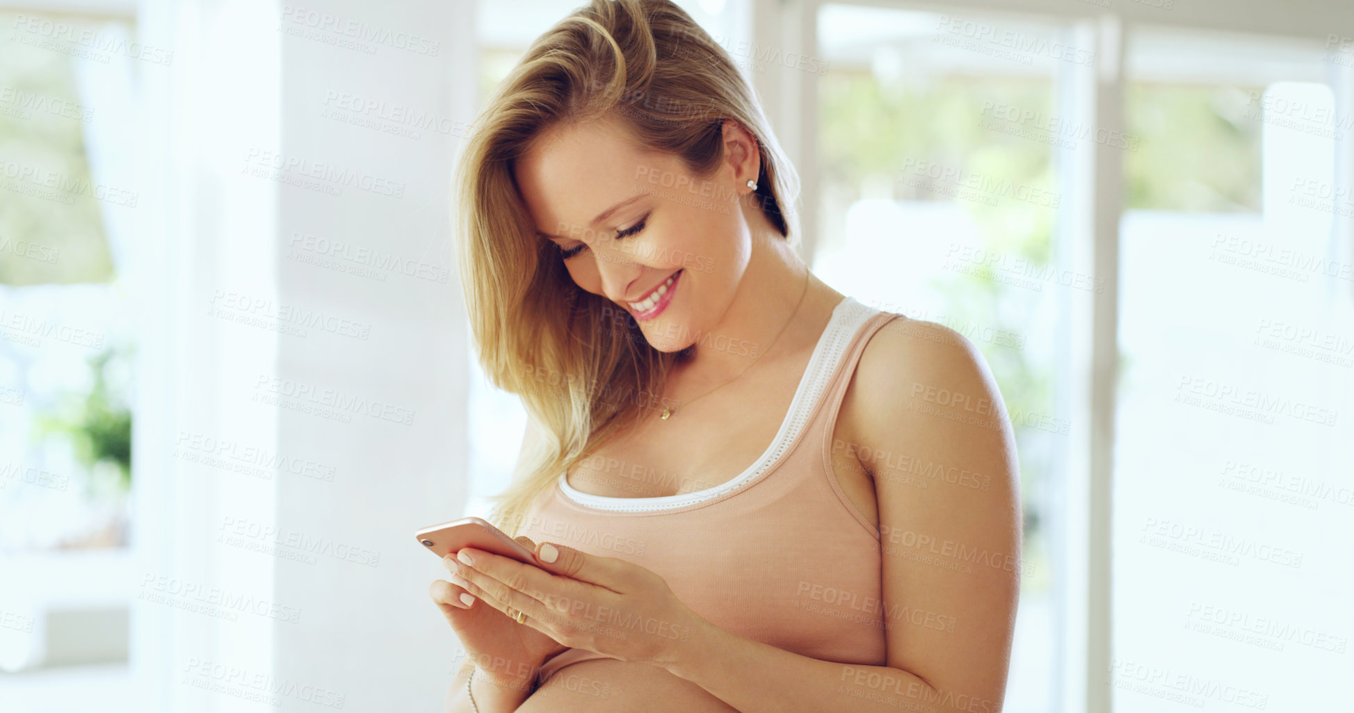 Buy stock photo Shot of a pregnant woman using a cellphone at home