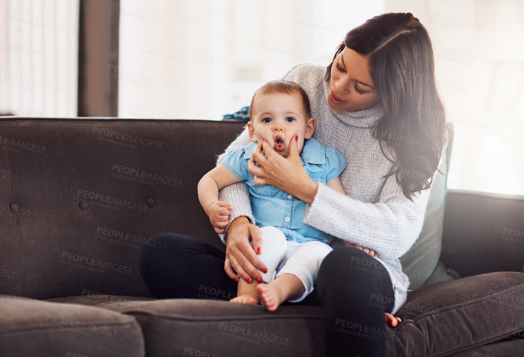 Buy stock photo Family, mother and baby on sofa in living room, holding hands for love and playful for support. Smile, motherhood and toddler with woman together, hug and play by sitting for relationship at home