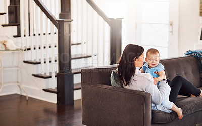 Buy stock photo Shot of an adorable baby girl bonding with her mother on the sofa at home