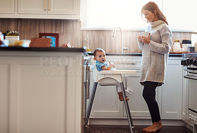 Buy stock photo Kitchen, mom and happy with baby in high chair in home with playing and busy with house keeping. Parent, woman and toddler for child development or growth with care, support and trust or bonding