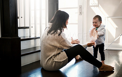 Buy stock photo Shot of an adorable baby girl walking into her mother’s open arms at home