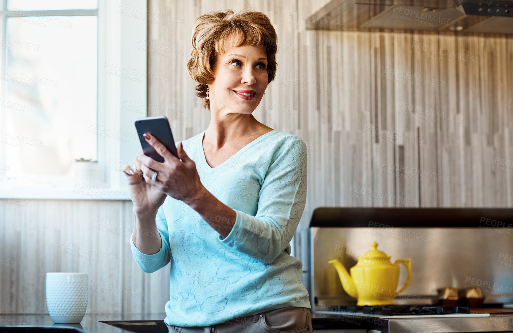 Buy stock photo Phone, thinking and senior woman in kitchen with smile, connection or scroll on social media. Morning, relax and elderly person in home with smartphone, online chat or mobile app for communication