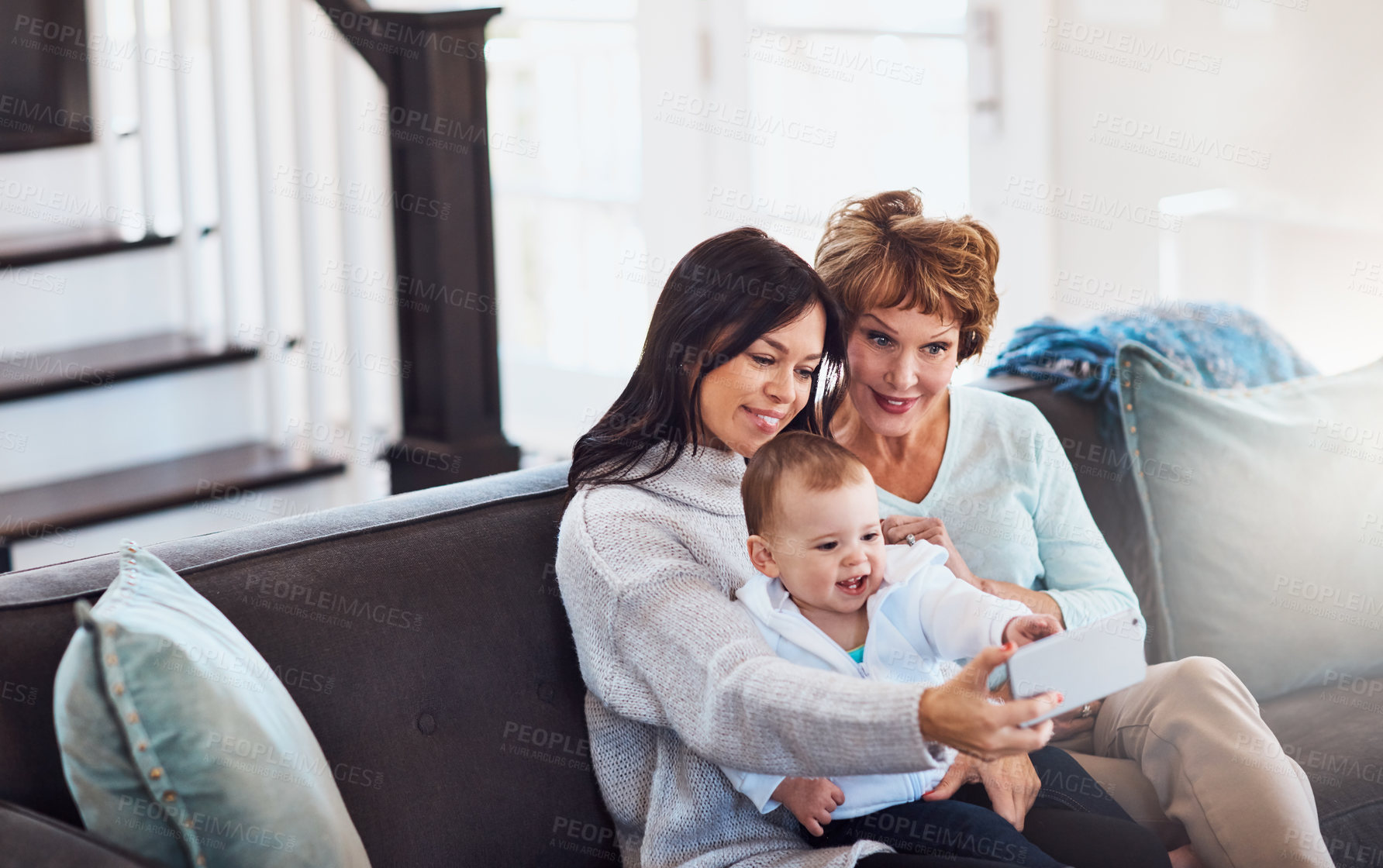 Buy stock photo Shot of a young woman taking selfies with her baby girl and mother at home