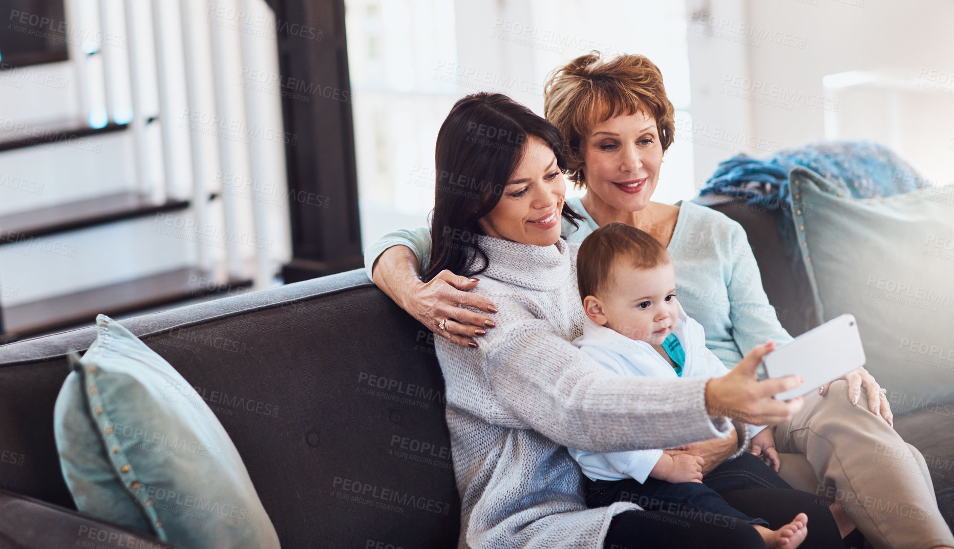 Buy stock photo Shot of a young woman taking selfies with her baby girl and mother at home