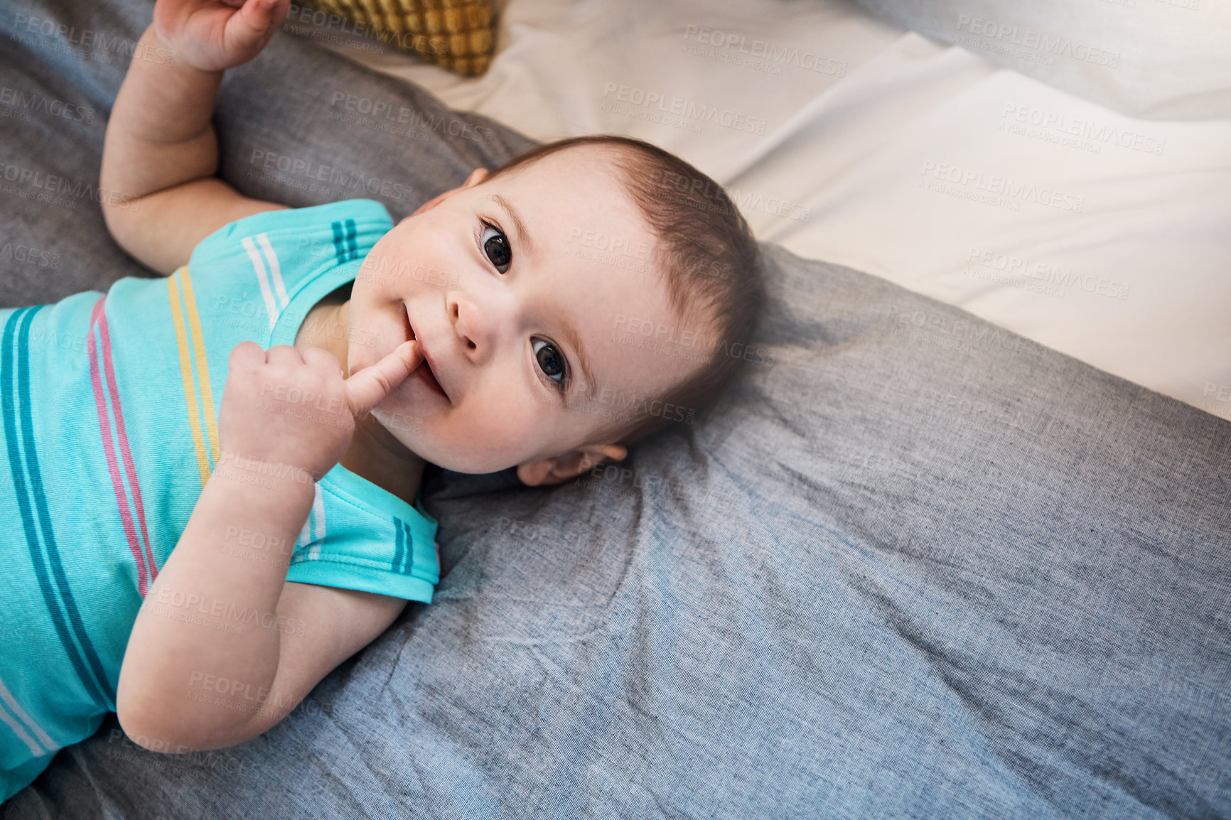 Buy stock photo High angle shot of an adorable baby girl lying on the bed at home