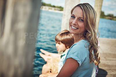 Buy stock photo Shot of a young mother and her family on a pier while out by the lake