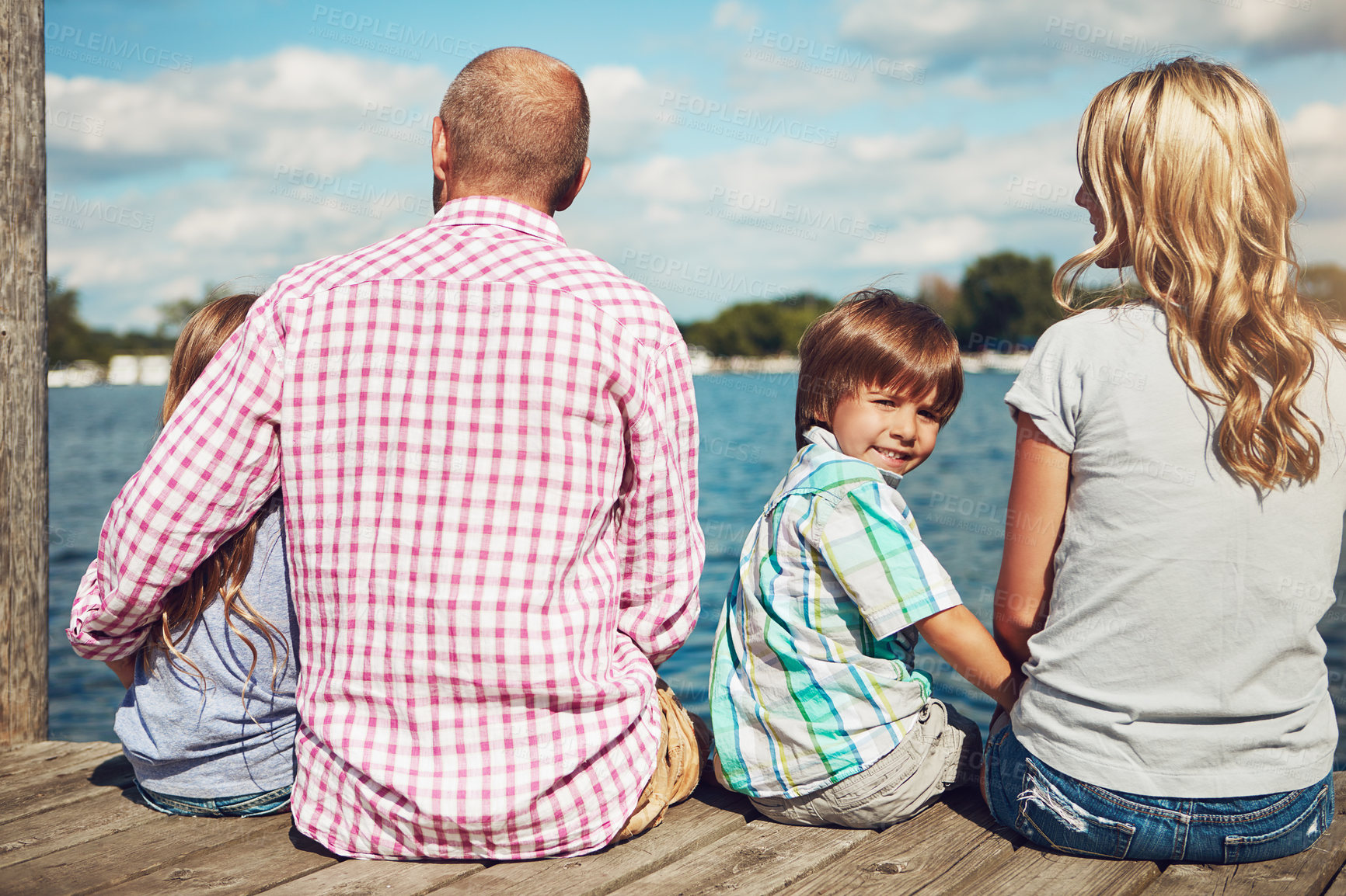 Buy stock photo Family, lake and jetty on vacation portrait, peace and travel to relax by water together. Parents, children and love on holiday by river or care in nature, pier and outdoor for relationship on trip