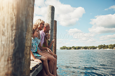 Buy stock photo Shot of a young family on a pier while out by the lake