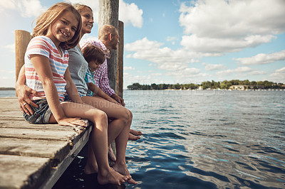 Buy stock photo Shot of a young family on a pier while out by the lake