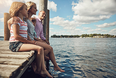 Buy stock photo Shot of a young family on a pier while out by the lake