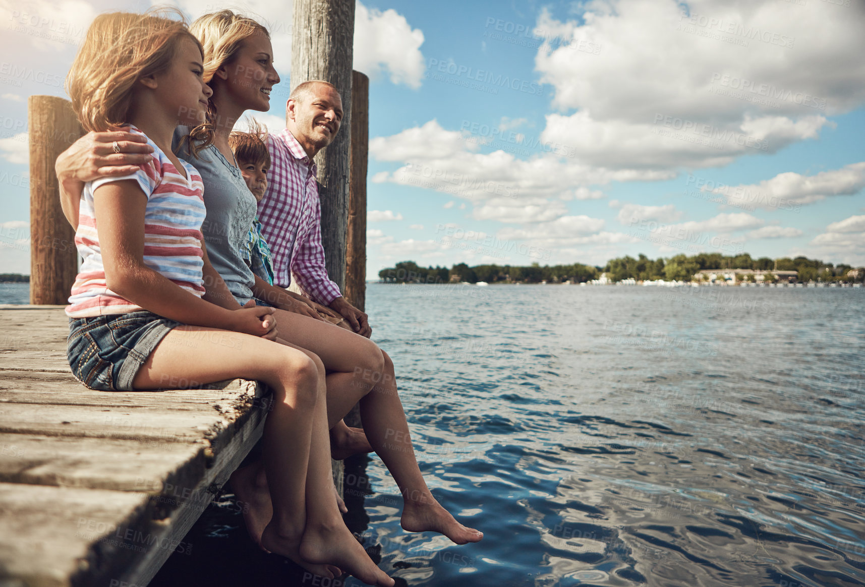 Buy stock photo Shot of a young family on a pier while out by the lake