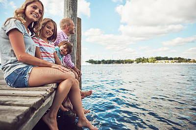 Buy stock photo Shot of a young family on a pier while out by the lake