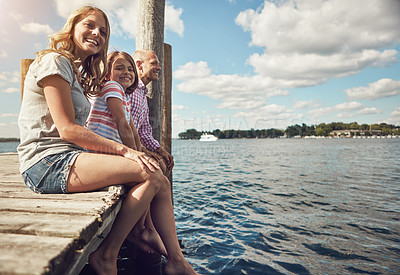 Buy stock photo Shot of a young family on a pier while out by the lake