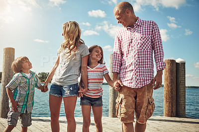 Buy stock photo Shot of a young family on a pier while out by the lake