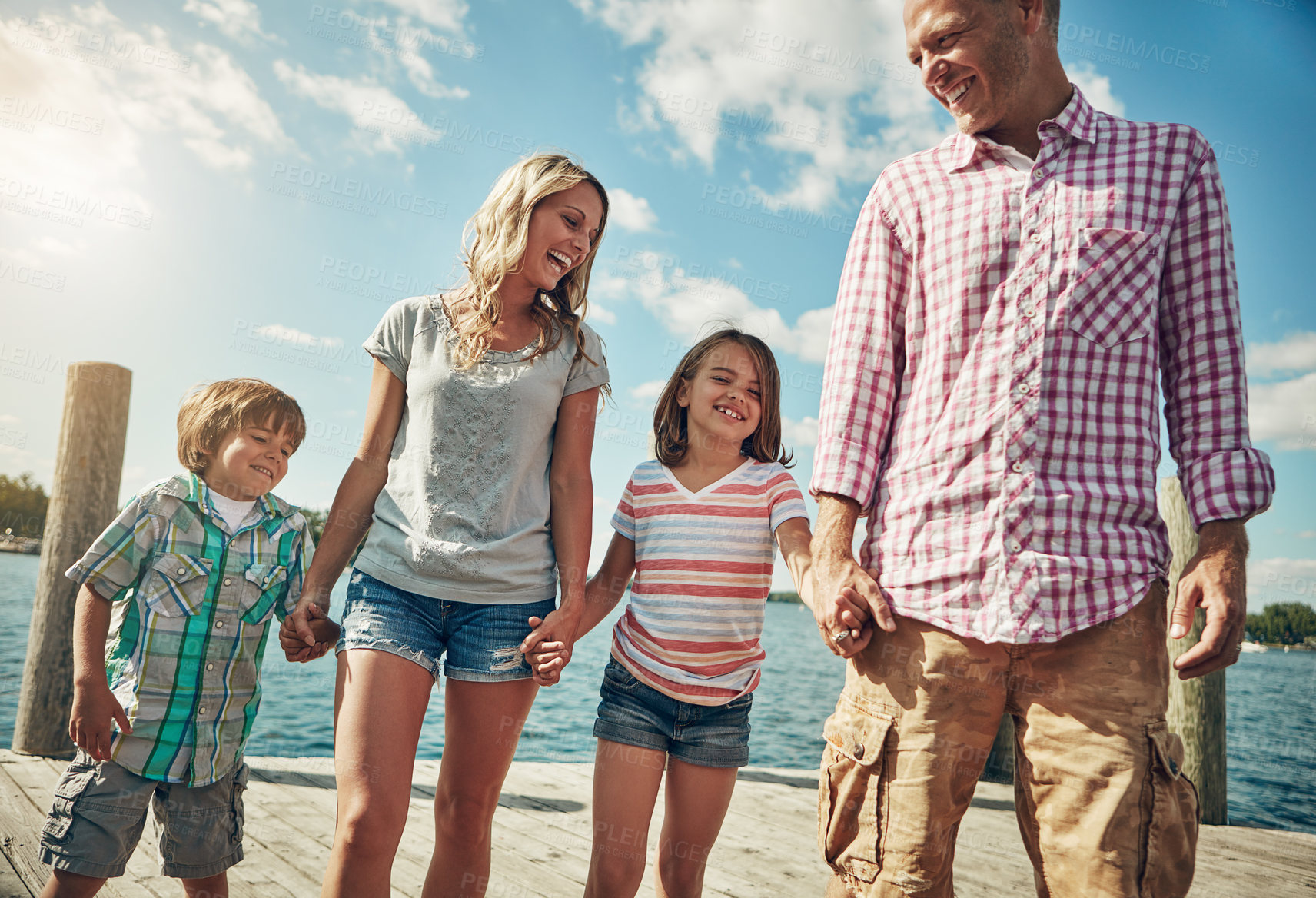 Buy stock photo Shot of a young family on a pier while out by the lake