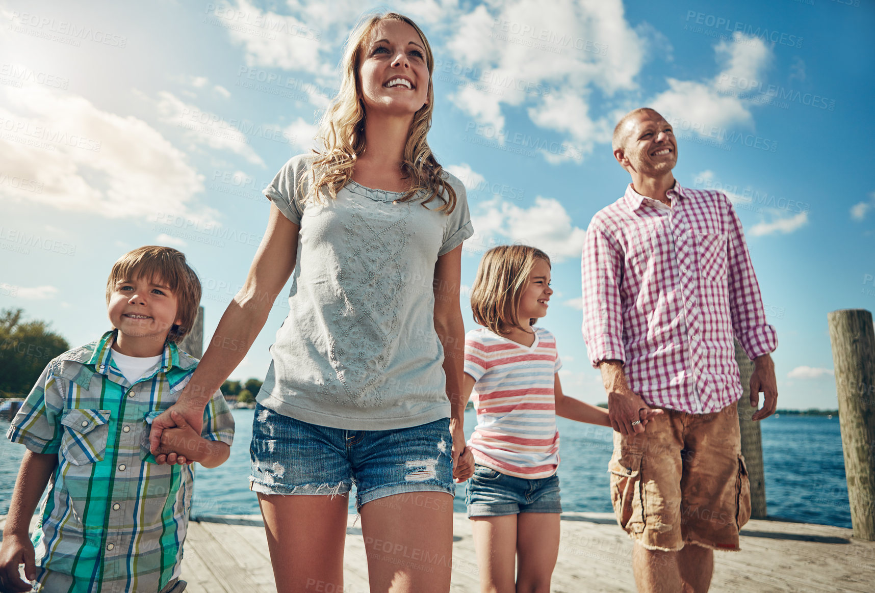 Buy stock photo Shot of a young family on a pier while out by the lake