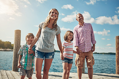 Buy stock photo Shot of a young family on a pier while out by the lake