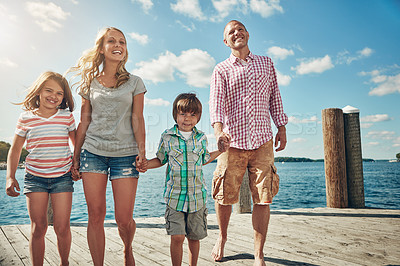 Buy stock photo Shot of a young family on a pier while out by the lake