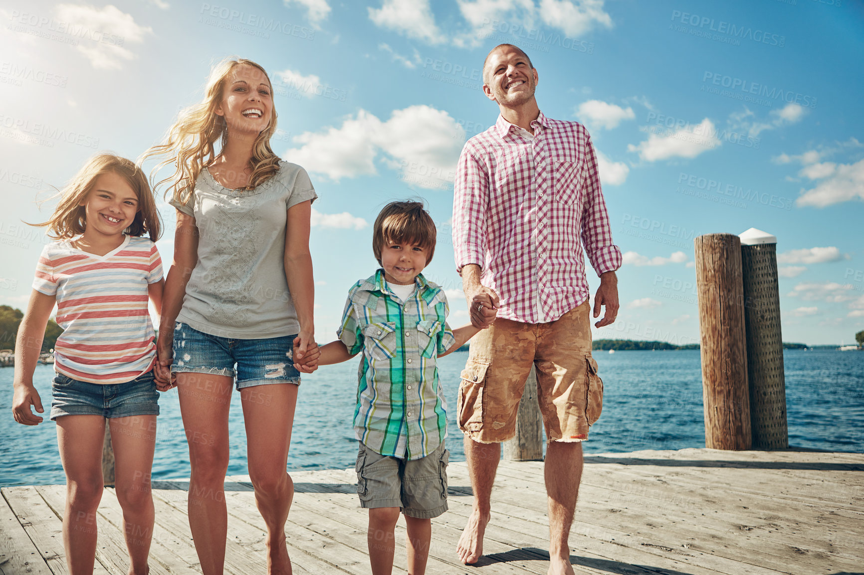 Buy stock photo Shot of a young family on a pier while out by the lake