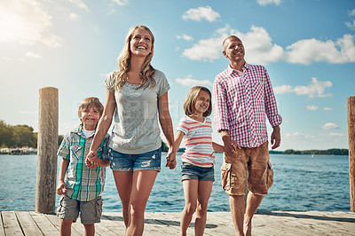 Buy stock photo Shot of a young family on a pier while out by the lake