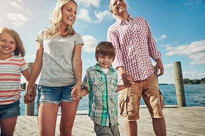 Buy stock photo Shot of a young family on a pier while out by the lake