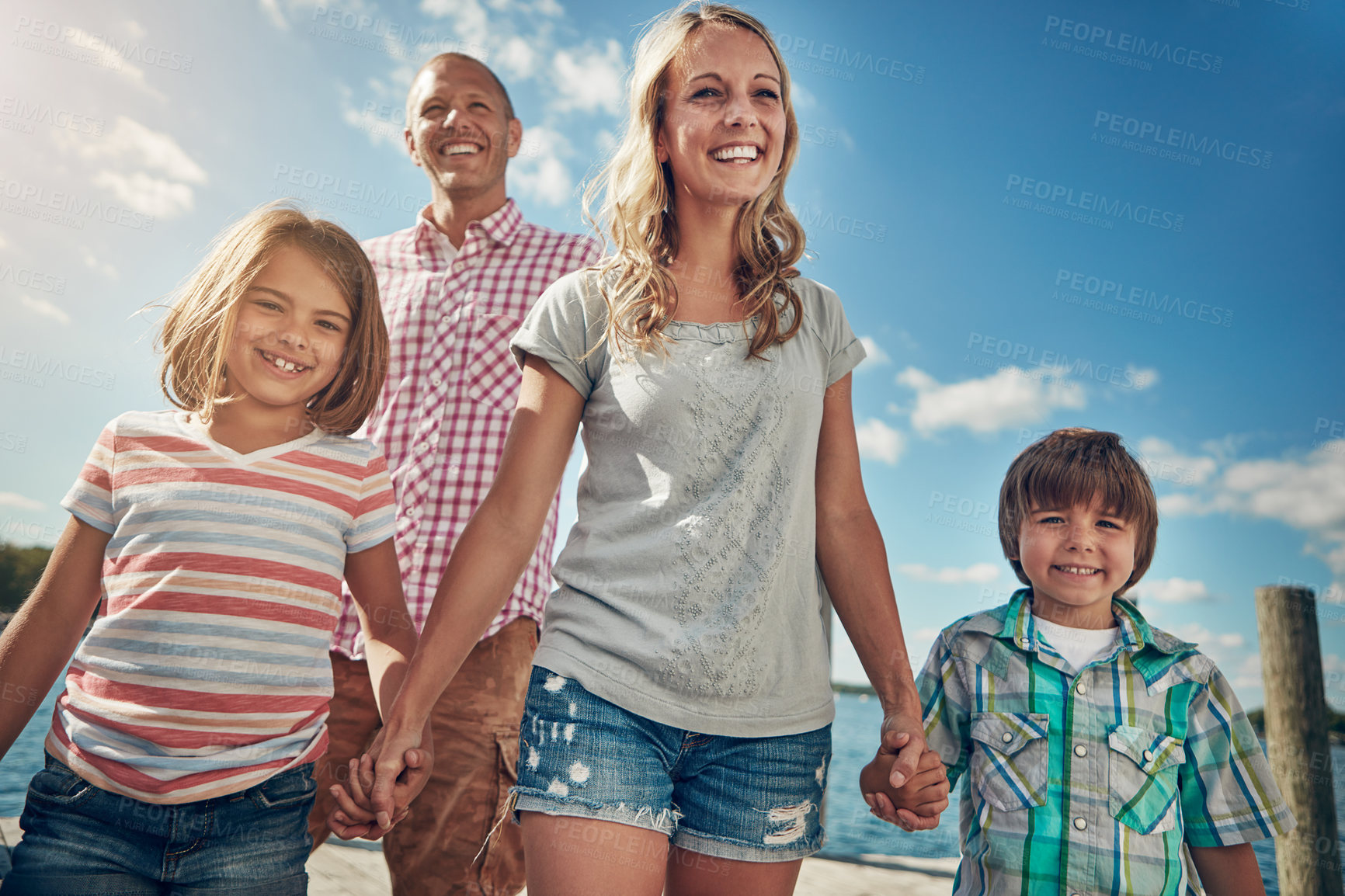 Buy stock photo Shot of a young family on a pier while out by the lake