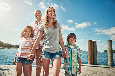 Buy stock photo Shot of a young family on a pier while out by the lake