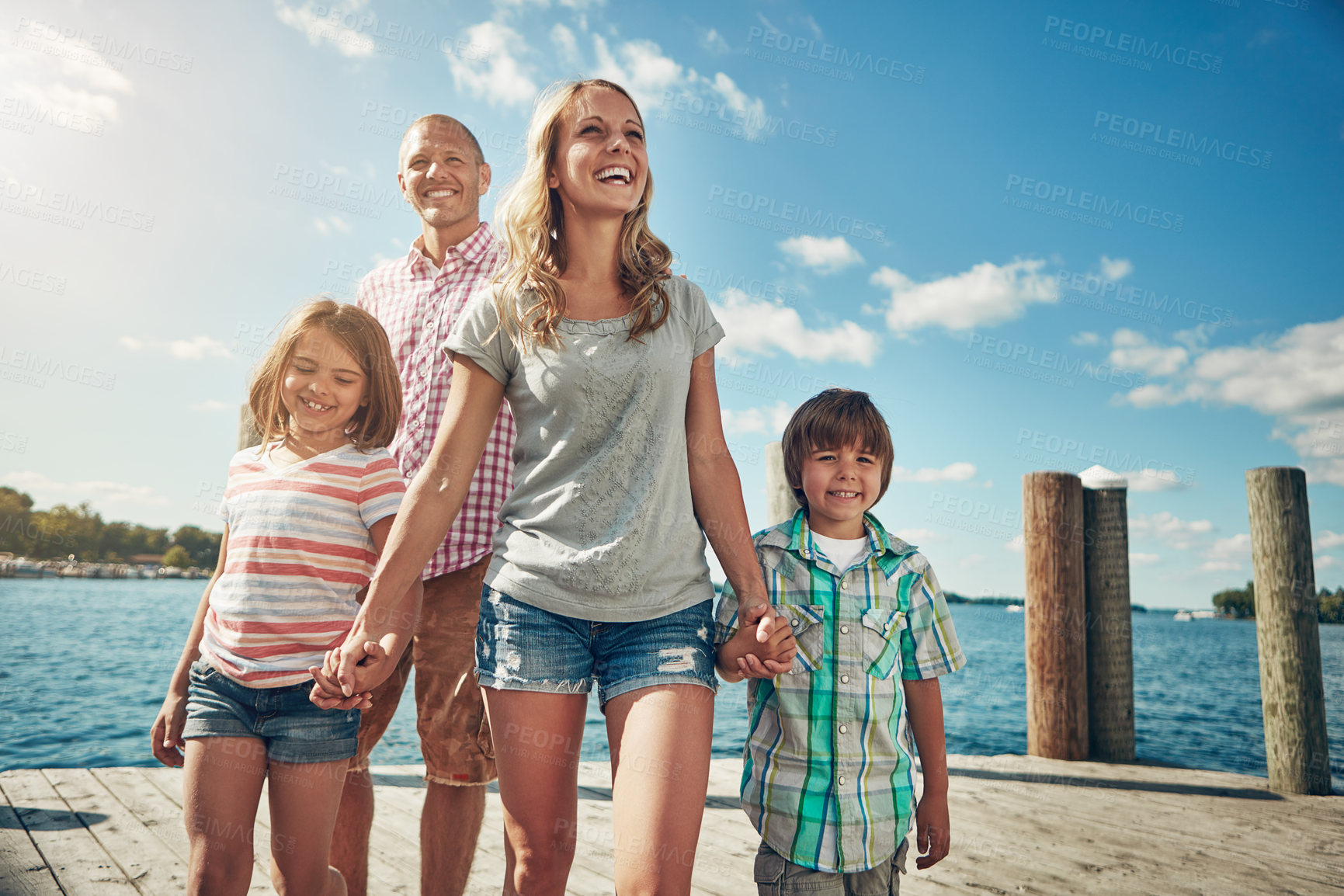 Buy stock photo Shot of a young family on a pier while out by the lake