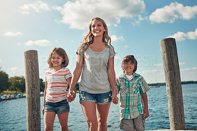 Buy stock photo Shot of a young family on a pier while out by the lake