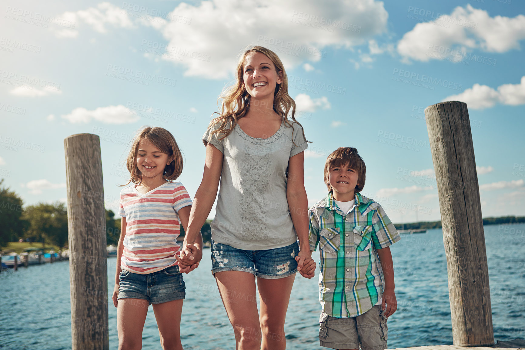 Buy stock photo Shot of a young family on a pier while out by the lake