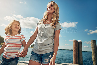 Buy stock photo Shot of a young mother and daughter on a pier while out by the lake