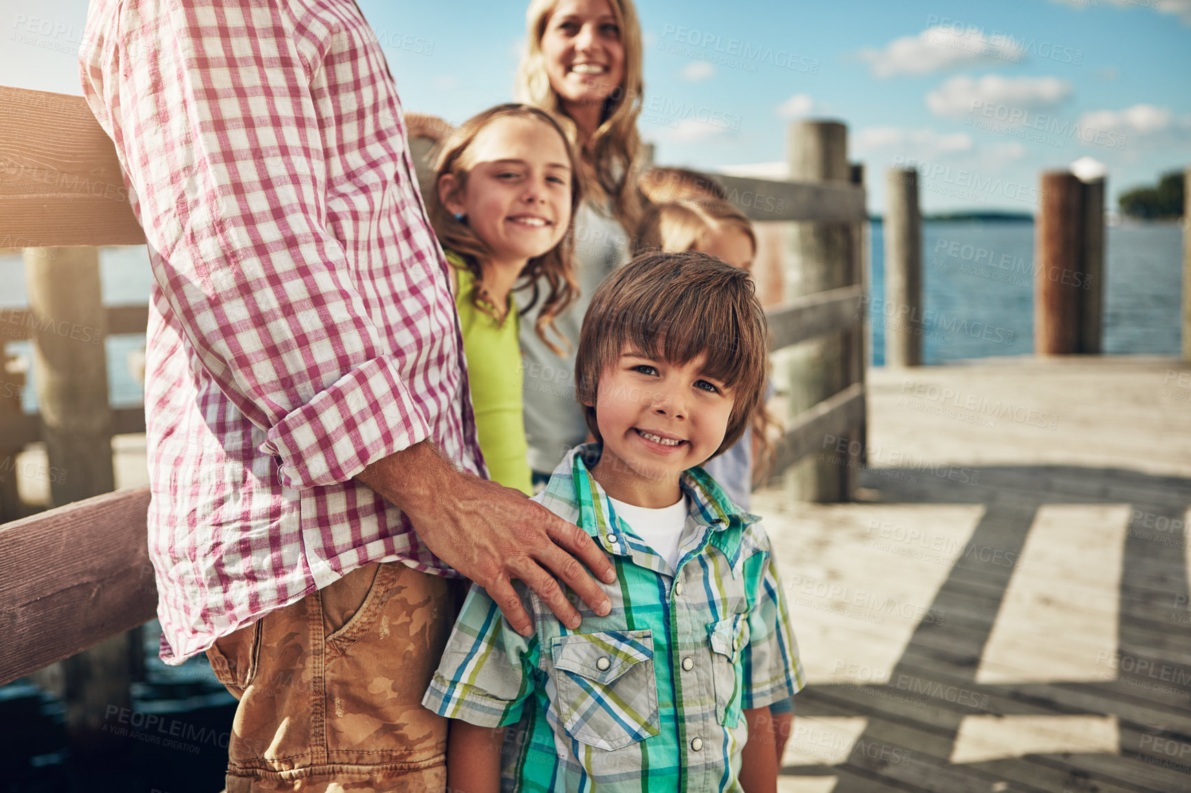 Buy stock photo Shot of a young family on a pier while out by the lake