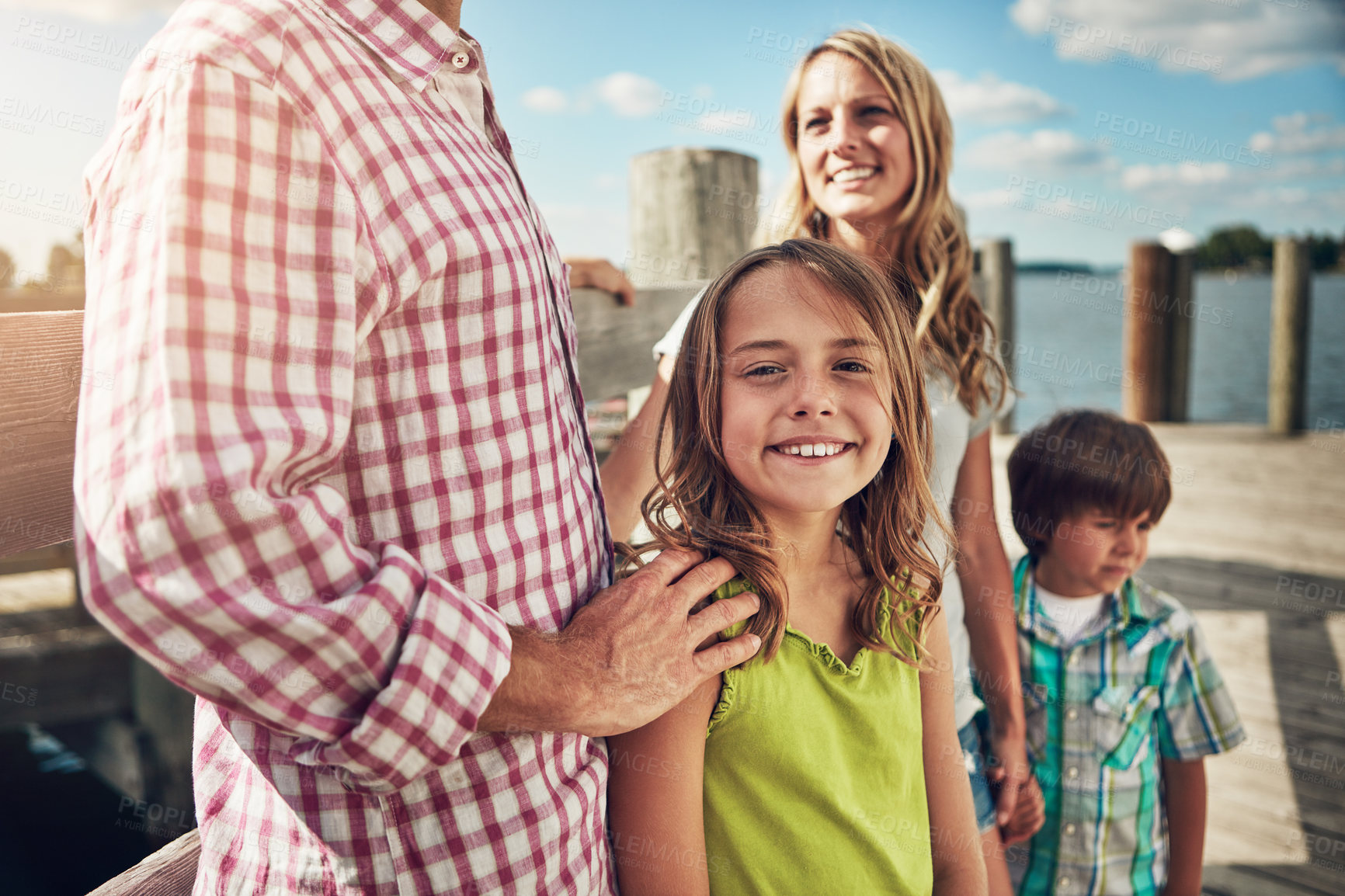 Buy stock photo Shot of a young family on a pier while out by the lake